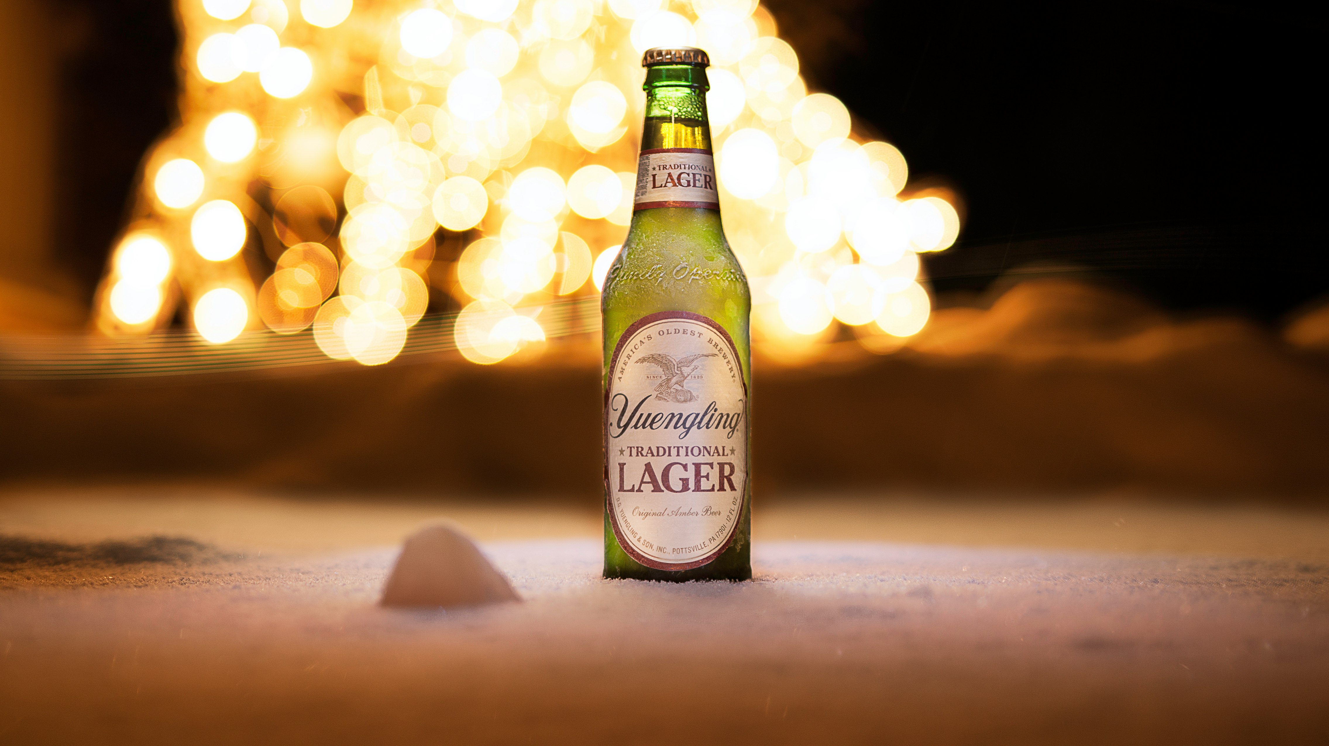 lager bottle on white sand beach